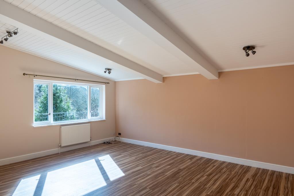 Lot: 164 - THREE-BEDROOM HOUSE IN SECLUDED LOCATION OVERLOOKING WOODLAND - Living room with sloped ceiling
